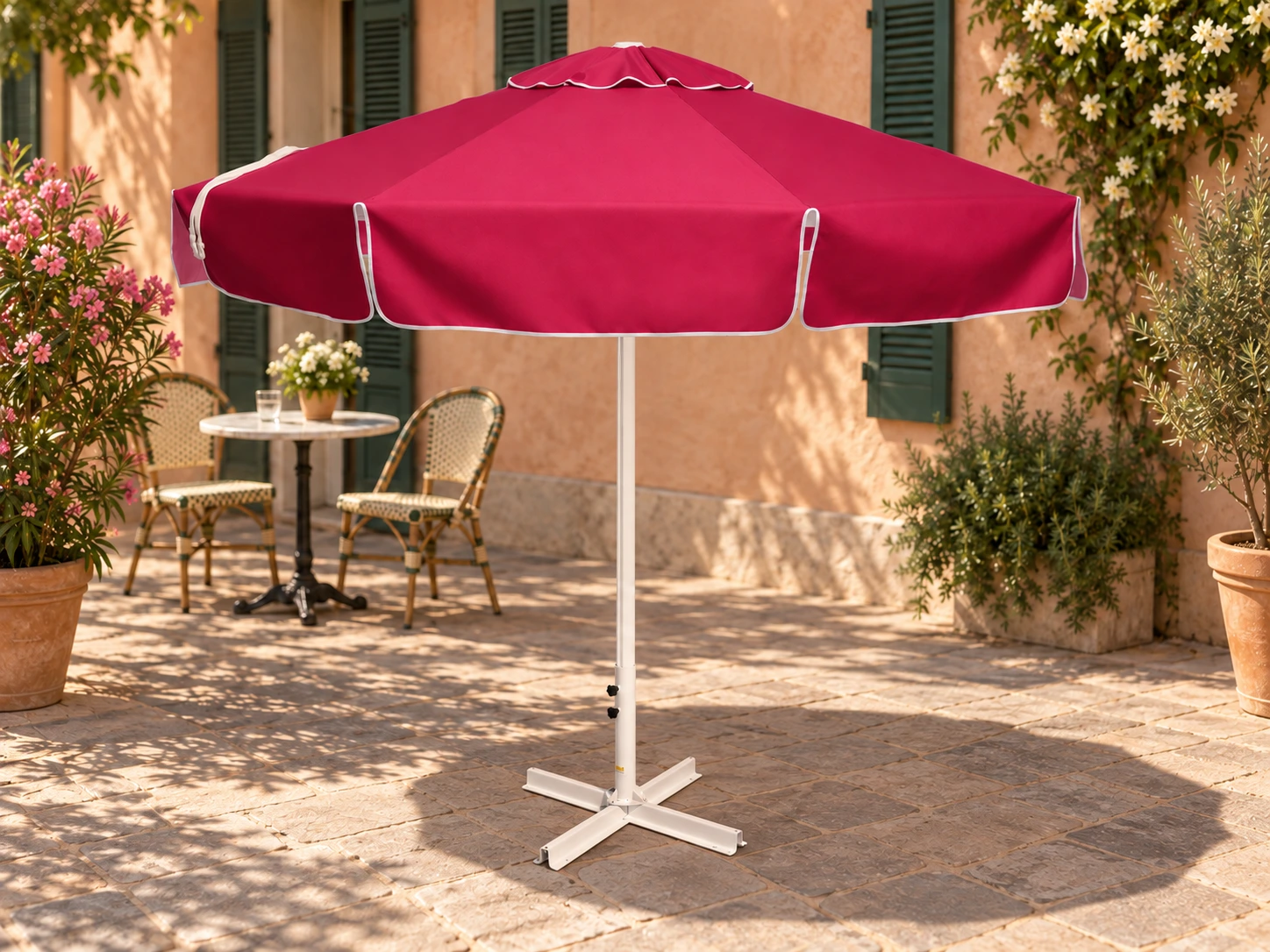 Parasol DANI rond de 2,5 mètres, toile rose, dans une cour de café