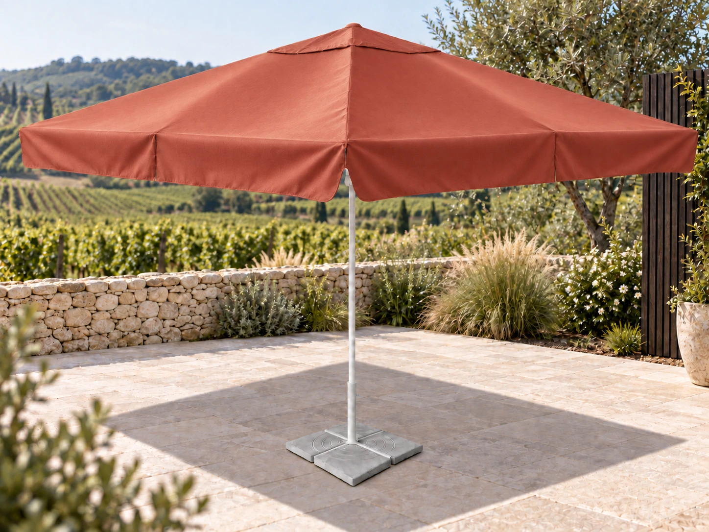 Parasol SOFIA 3,5 × 3,5 m, toile terracotta satinée, dans un jardin bordé de vignes